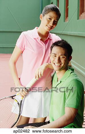 Couple in tennis outfits, looking at camera, smiling View Large Photo Image Stock Image - Couple in tennis outfits, looking at camera, smiling . Fotosearch