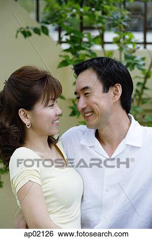 Couple looking at each other, smiling View Large Photo Image Stock Photograph - Couple looking at each other, smiling . Fotosearch
