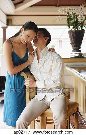 Couple next to bar counter, man whispering in womans ear View Large Photo Image Stock Photo - Couple next to bar counter, man whispering in womans ear . Fotosearch
