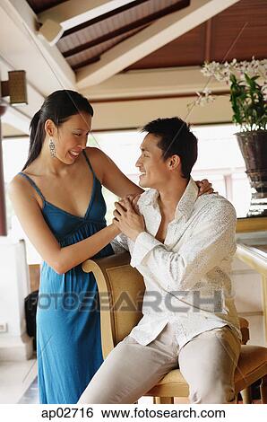 Couple next to bar counter, man sitting, woman standing, looking at each other View Large Photo Image Stock Photograph - Couple next to bar counter, man sitting, woman standing, looking at each other . Fotosearch