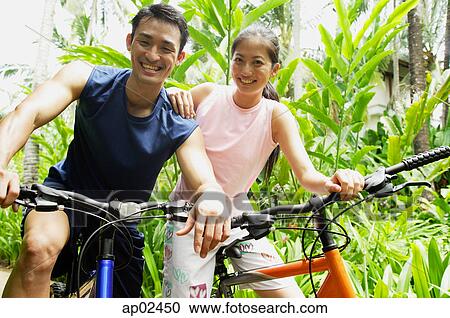 Couple on bicycles, smiling View Large Photo Image Stock Image - Couple on bicycles, smiling . Fotosearch