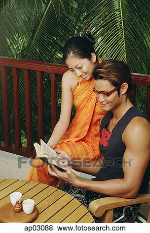 Couple reading book on patio View Large Photo Image Stock Photo - Couple reading book on patio . Fotosearch