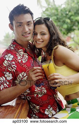 Couple side by side, holding drinks, looking at camera View Large Photo Image Stock Image - Couple side by side, holding drinks, looking at camera . Fotosearch
