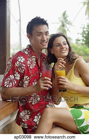 Couple side by side, holding drinks View Large Photo Image Stock Photo - Couple side by side, holding drinks . Fotosearch