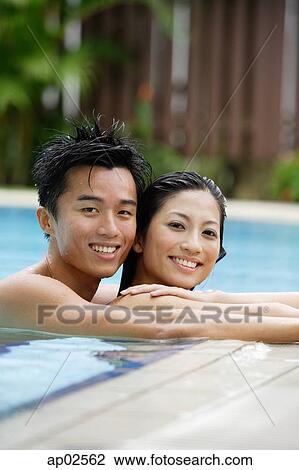 Couple side by side in swimming pool, smiling, portrait View Large Photo Image Stock Image - Couple side by side in swimming pool, smiling, portrait. Fotosearch