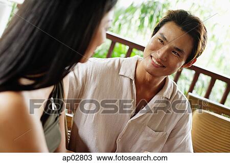 Stock Image - Couple sitting and looking at each other . Fotosearch