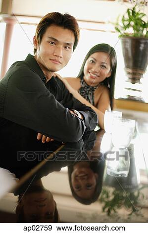 Couple sitting at bar counter, looking at camera, smiling View Large Photo Image Stock Photo - Couple sitting at bar counter, looking at camera, smiling . Fotosearch