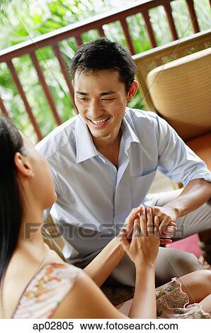 Couple sitting face to face, holding hands View Large Photo Image Stock Photography - Couple sitting face to face, holding hands . Fotosearch