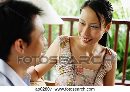 Couple sitting face to face, smiling View Large Photo Image Stock Photo - Couple sitting face to face, smiling . Fotosearch