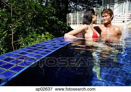 Couple sitting in swimming pool View Large Photo Image Stock Photo - Couple sitting in swimming pool. Fotosearch
