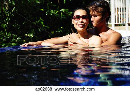 Couple sitting in swimming pool, woman smiling View Large Photo Image Stock Photo - Couple sitting in swimming pool, woman smiling . Fotosearch