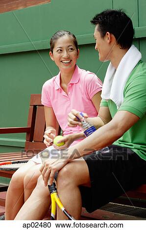 Couple sitting on bench in tennis court, looking at each other View Large Photo Image Stock Image - Couple sitting on bench in tennis court, looking at each other. Fotosearch
