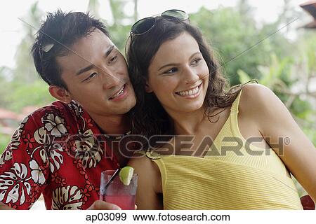 Stock Photo - Couple sitting side by side, cheek to cheek, looking away . Fotosearch