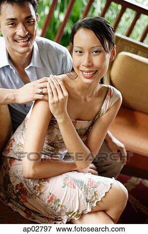 Couple sitting together, smiling at camera View Large Photo Image Stock Photo - Couple sitting together, smiling at camera . Fotosearch