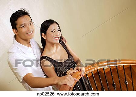 Couple standing at staircase, smiling View Large Photo Image Stock Photograph - Couple standing at staircase, smiling . Fotosearch