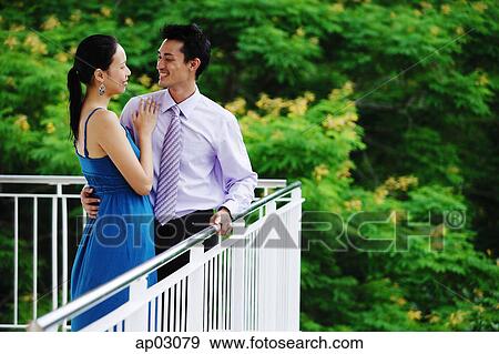 Couple standing on balcony, embracing, face to face View Large Photo Image Stock Photo - Couple standing on balcony, embracing, face to face . Fotosearch