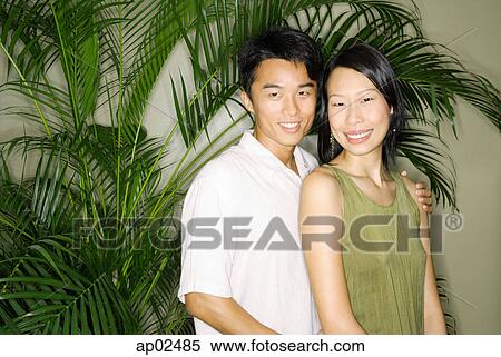 Stock Photography - Couple standing side by side, smiling at camera . Fotosearch