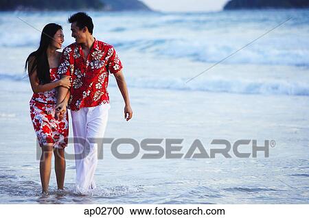 Couple walking on beach, ankle deep in water, holding hands View Large Photo Image Stock Image - Couple walking on beach, ankle deep in water, holding hands . Fotosearch