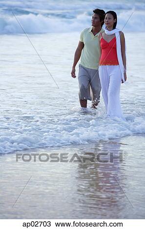 Couple walking on beach, ankle deep in water View Large Photo Image Stock Image - Couple walking on beach, ankle deep in water. Fotosearch