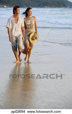 Couple walking on beach, looking away View Large Photo Image Picture - Couple walking on beach, looking away . Fotosearch