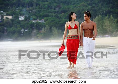 Couple walking side by side along beach View Large Photo Image Stock Image - Couple walking side by side along beach . Fotosearch