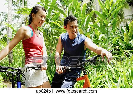 Couple with bicycles in park View Large Photo Image Stock Image - Couple with bicycles in park. Fotosearch