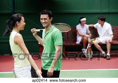 Couples at tennis court, talking View Large Photo Image Picture - Couples at tennis court, talking . Fotosearch