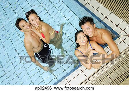 Couples in swimming pool looking at camera View Large Photo Image Stock Photograph - Couples in swimming pool looking at camera . Fotosearch