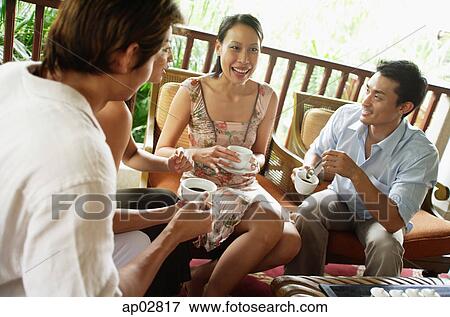 Couples sitting at home having coffee and talking View Large Photo Image Stock Photo - Couples sitting at home having coffee and talking . Fotosearch