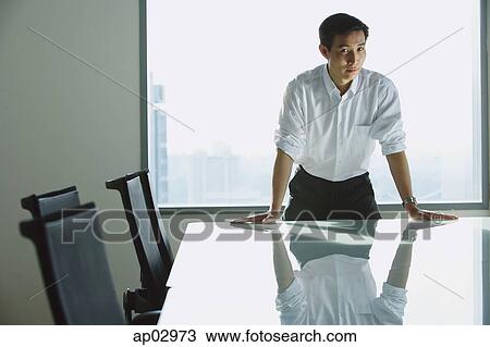 Executive standing with hands on table, looking at camera View Large Photo Image Stock Image - Executive standing with hands on table, looking at camera . Fotosearch