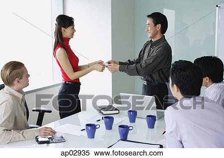 Executives exchanging business cards in meeting room View Large Photo Image Stock Photography - Executives exchanging business cards in meeting room . Fotosearch