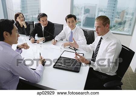 Executives having a discussion around conference table, Caucasian man at the head of the table View Large Photo Image Stock Photo - Executives having a discussion around conference table, Caucasian man at the head of the table . Fotosearch