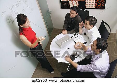 Executives in meeting room, female executive standing, talking View Large Photo Image Stock Image - Executives in meeting room, female executive standing, talking. Fotosearch