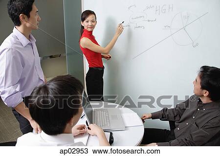 Executives in meeting room, female executive writing on white board View Large Photo Image Stock Image - Executives in meeting room, female executive writing on white board. Fotosearch