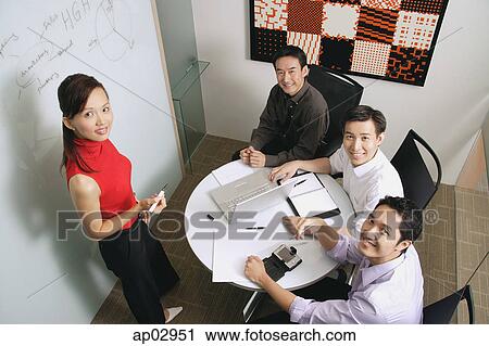 Executives in meeting room, looking up at camera View Large Photo Image Stock Image - Executives in meeting room, looking up at camera. Fotosearch