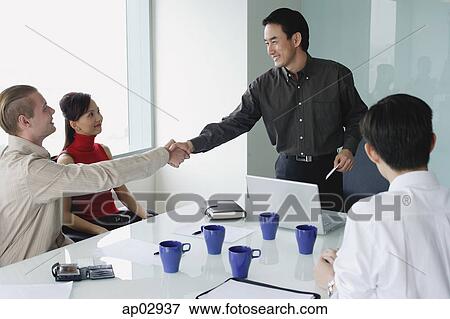 Executives in meeting room, two men shaking hands View Large Photo Image Stock Photo - Executives in meeting room, two men shaking hands . Fotosearch