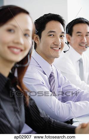 Executives with headsets, smiling at camera View Large Photo Image Stock Photo - Executives with headsets, smiling at camera . Fotosearch