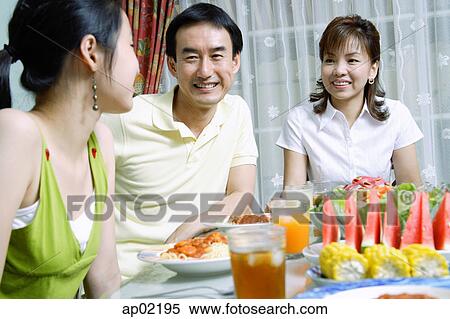 Stock Photography - Family with teenage daughter at dining table . Fotosearch