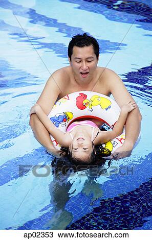 Father and daughter in swimming pool, daughter using inflatable ring View Large Photo Image Stock Image - Father and daughter in swimming pool, daughter using inflatable ring. Fotosearch
