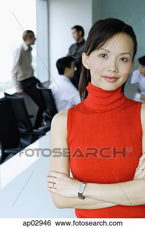 Female executive, looking at camera, people in the background View Large Photo Image Stock Photograph - Female executive, looking at camera, people in the background . Fotosearch
