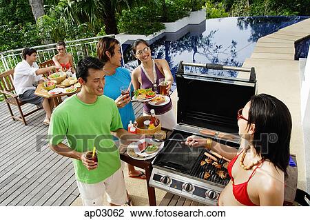 Stock Image - Friends at barbeque party . Fotosearch