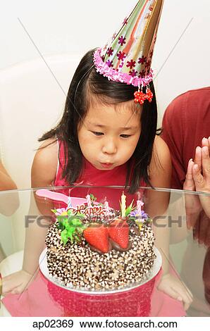 Girl blowing out birthday cake View Large Photo Image Stock Photo - Girl blowing out birthday cake . Fotosearch