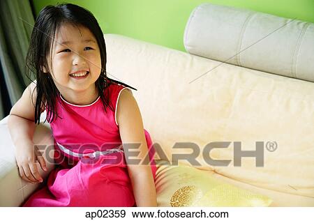 Stock Photo - Girl on sofa, smiling . Fotosearch