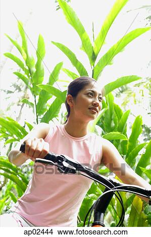 Girl riding a bike through a park View Large Photo Image Picture - Girl riding a bike through a park . Fotosearch
