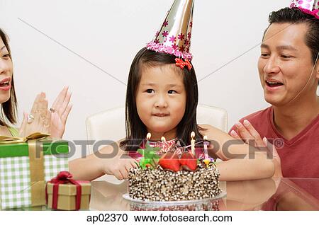 Girl with birthday cake, parents on either side clapping View Large Photo Image Stock Image - Girl with birthday cake, parents on either side clapping . Fotosearch