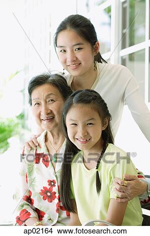 Picture - Grandmother sitting with her granddaughters . Fotosearch