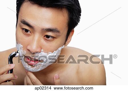 Man holding shaver to face, shaving View Large Photo Image Picture - Man holding shaver to face, shaving . Fotosearch