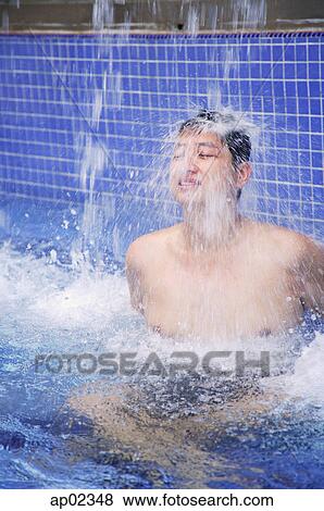 Man in swimming pool, water cascading over him View Large Photo Image Stock Photo - Man in swimming pool, water cascading over him . Fotosearch