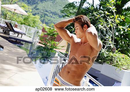 Man in swimming trunks, hands on head View Large Photo Image Stock Photo - Man in swimming trunks, hands on head . Fotosearch