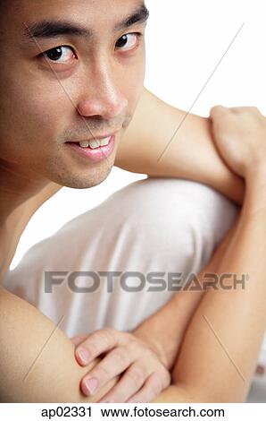 Stock Image - Man sitting, looking at camera . Fotosearch